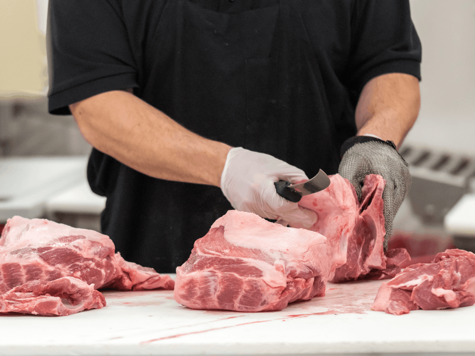 Butcher preparing cuts of meat in a professional workspace